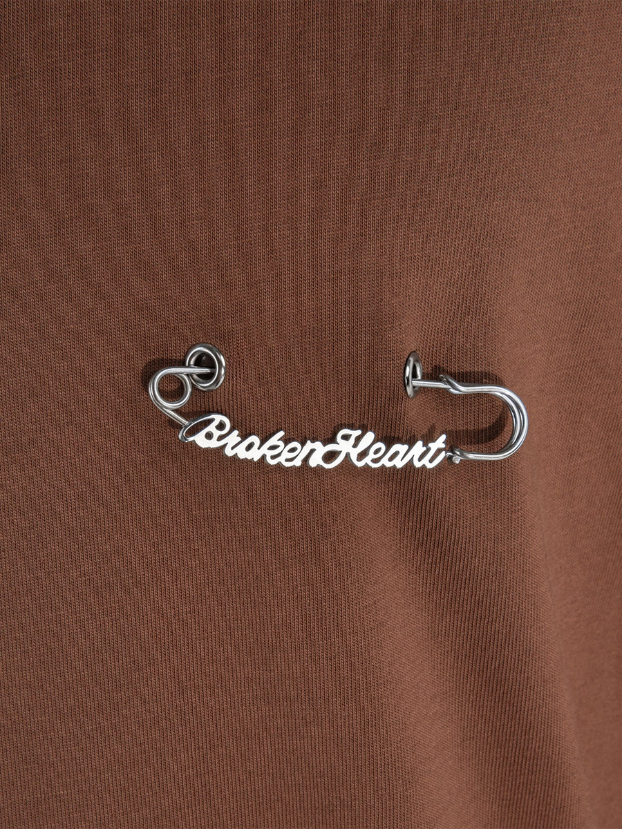 T-shirt marrone Brokenheart, dettaglio della spilla da balia