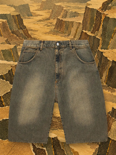 De bruine jeansshort Aged in een canyon van oker en olijfgroen papier.