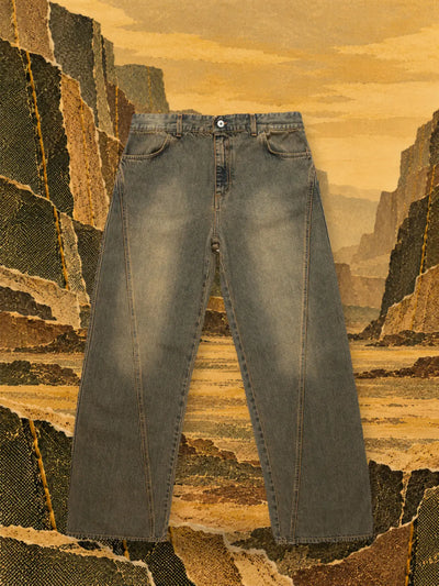 De bruine jeans Aged in een canyon van oker en olijfgroen papier, onder een gouden hemel.