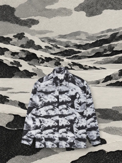 La camicia a maniche lunghe Black Camo in una valle di colline di carta tagliata con le stesse forme della mimetica.