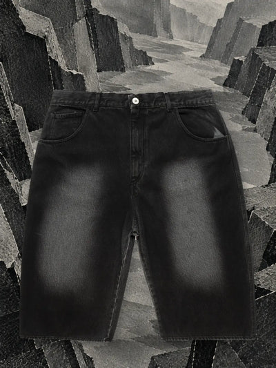 De verwassen zwarte jeansshort in een canyon met wanden van zwart en grijs papier.