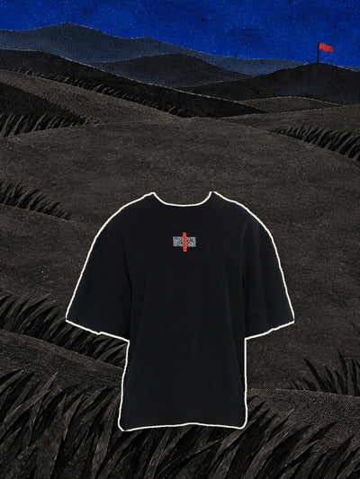 Den svarta t-shirten Flag med den röda etiketten på bröstet, ovanför kullar av svart papper under en blå natthimmel.
