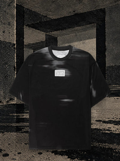 Den svarta t-shirten Leak i ett rum av mörkt papper, med svart bläck som rinner ner på golvet i långa strimmor.