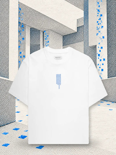 Den vita t-shirten Litkid i ett rum av vitt papper, där ett regn av små blå pappersrutor faller.