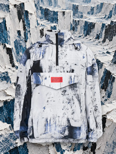 Den vita anoraken Rugged mellan väggar av rivet vitt och blått papper.