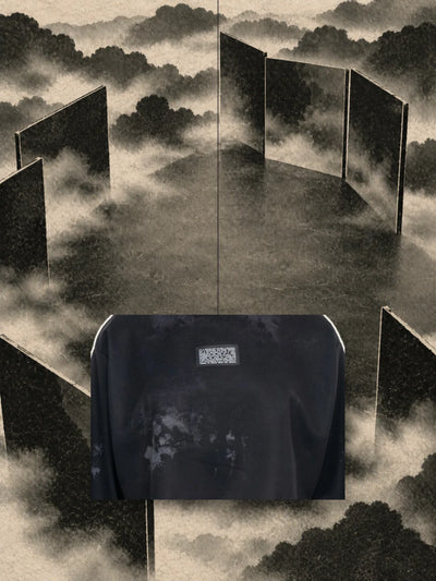 En bit av trycket från den korta svarta sweatshirten Triodrome, hängd i en tråd bland paneler av mörkt papper och dimma.