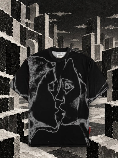Den svarta t-shirten Unkiss Black bland kuber av rivet vitt och svart papper, under en grå himmel.